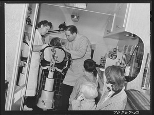 FSA (Farm Security Administration) dentist and migrant child in the FSA dental trailer at the FSA camp for farm families. Caldwell, Idaho (November 1941) - Russell Lee