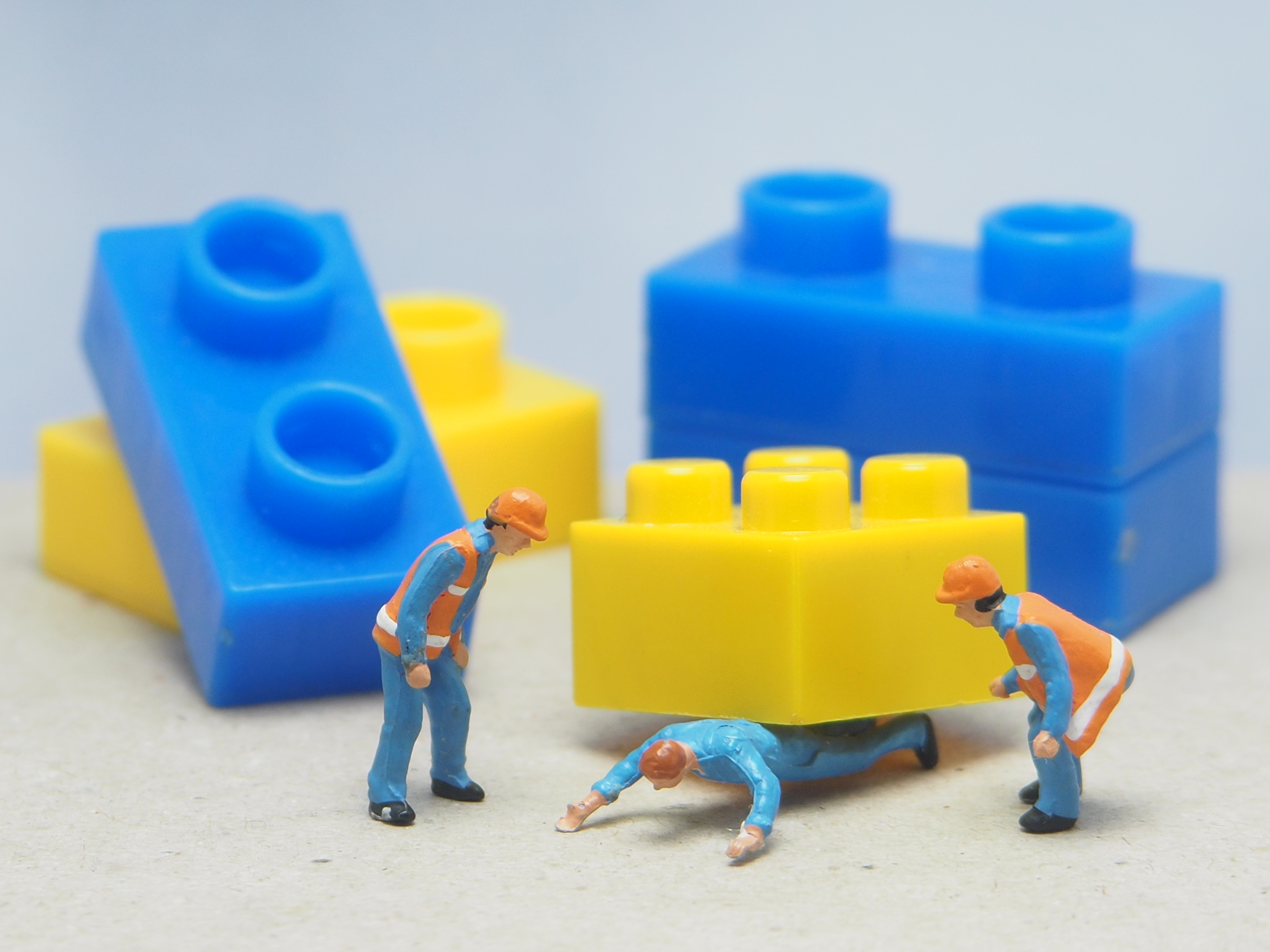 Diorama photography concept design. Minifigure of worker character trapped under the block.