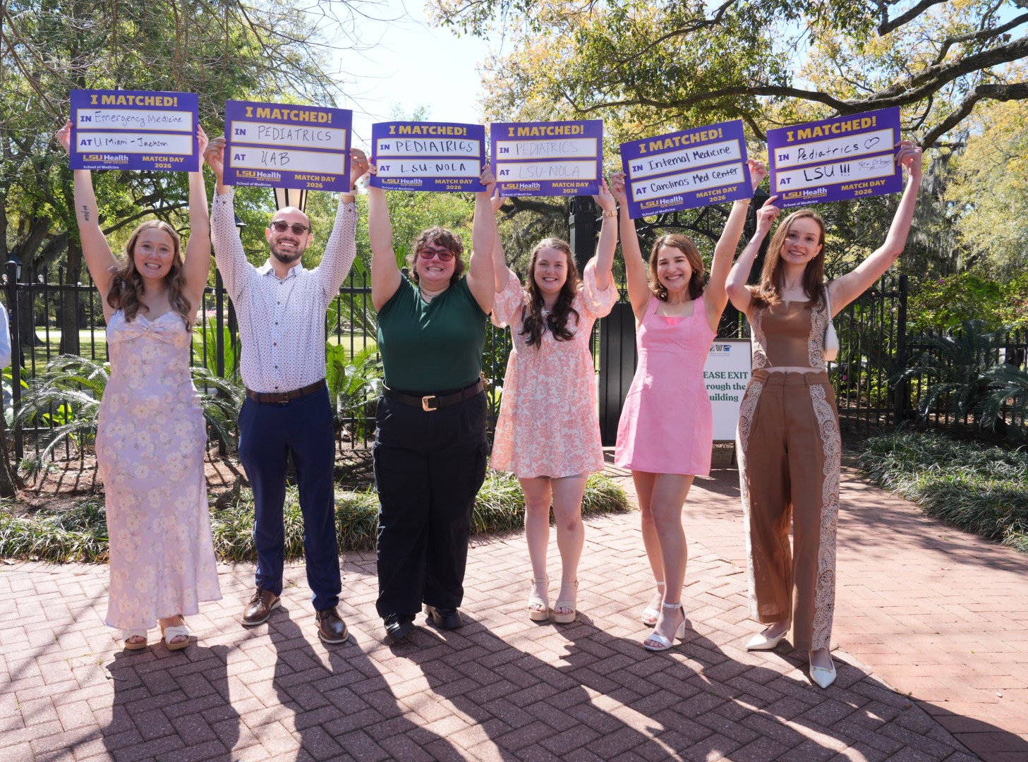 LSU Health New Orleans fourth-year medical students hold up signs revealing where they matched for residency. 